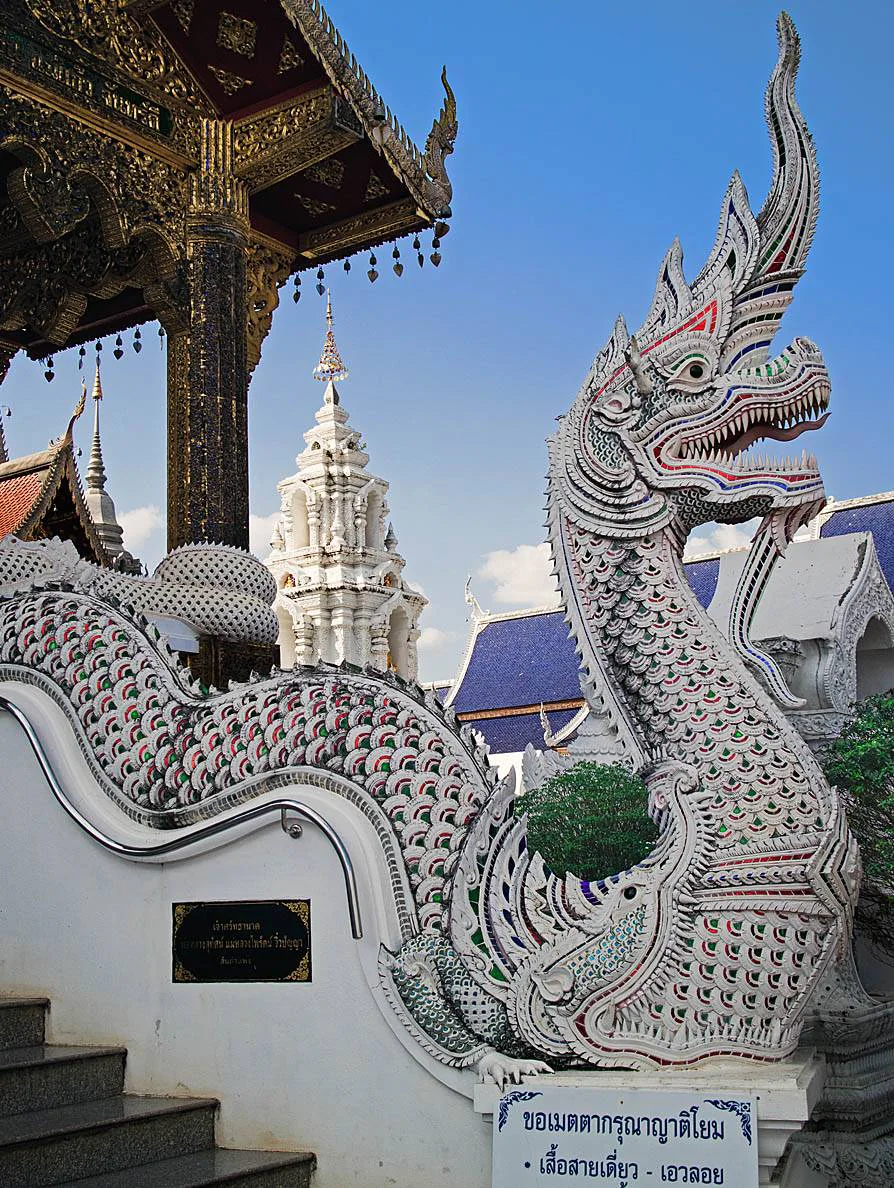 Green Nāga sculpture with extended serpent body at Wat Baan Den in Chiang Mai.