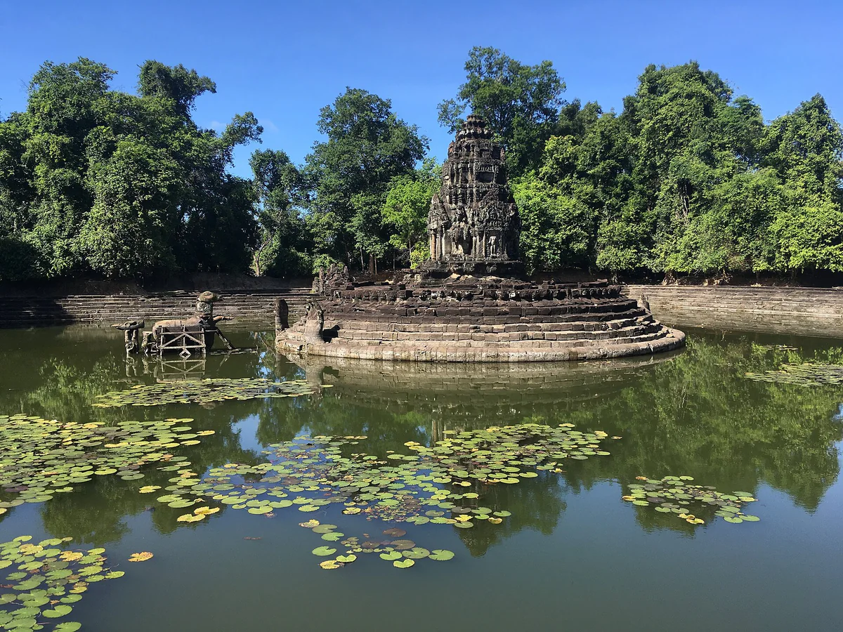 Stone-lined water basin and towers at Neak Pean in Angkor.